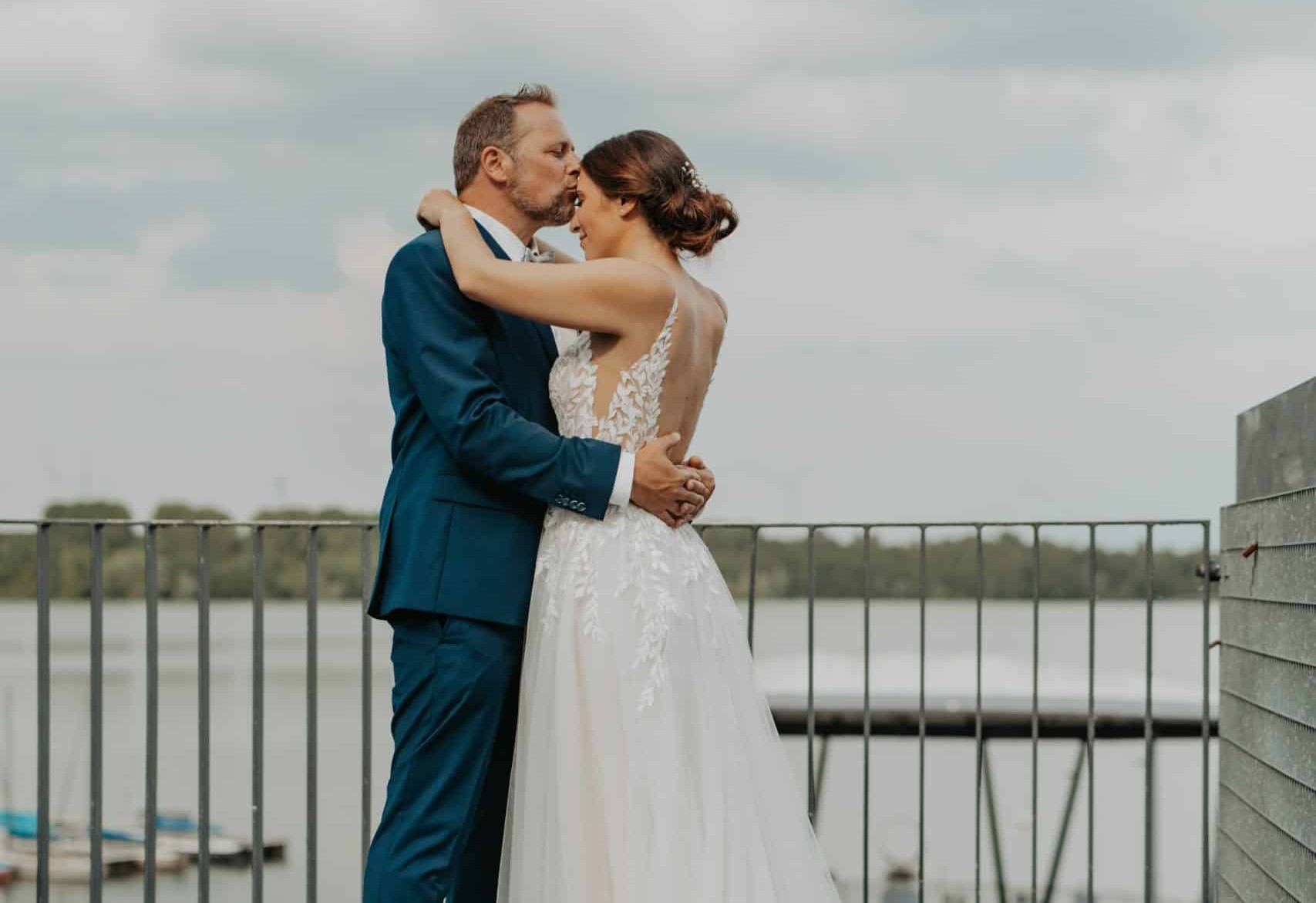 Brautpaar genießt einen ruhigen Moment am Wasser auf ihrer Hochzeit